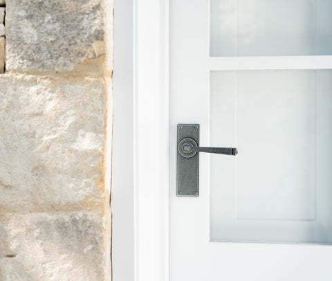 From The Anvil's Pewter lever latch door handle on a white door