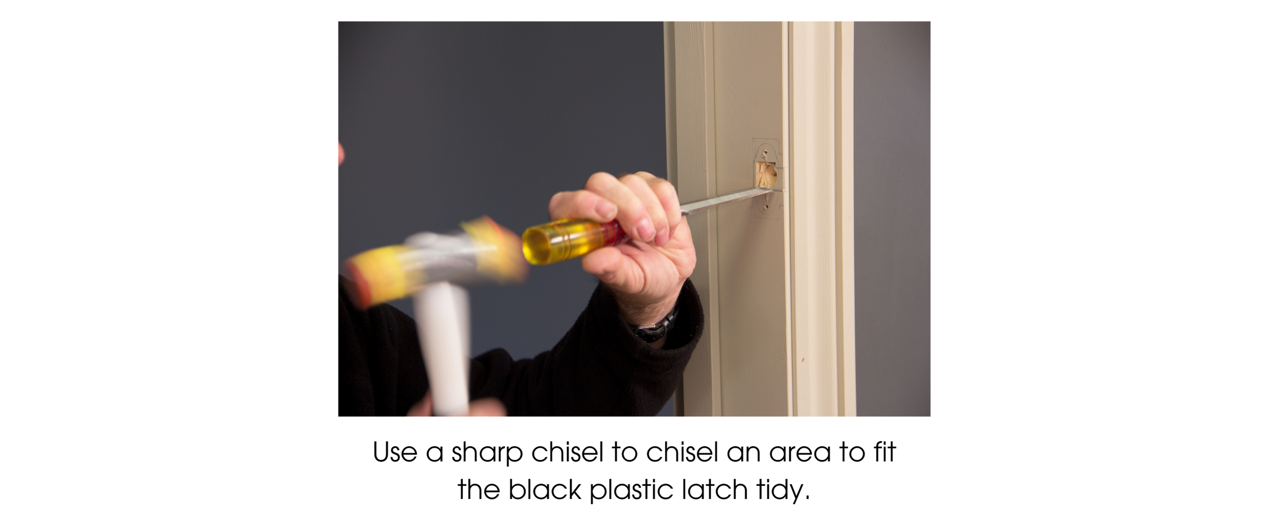 Person using a sharp chisel and hammer to carve out space in a door frame to fit a black plastic latch tidy for a mortice latch.