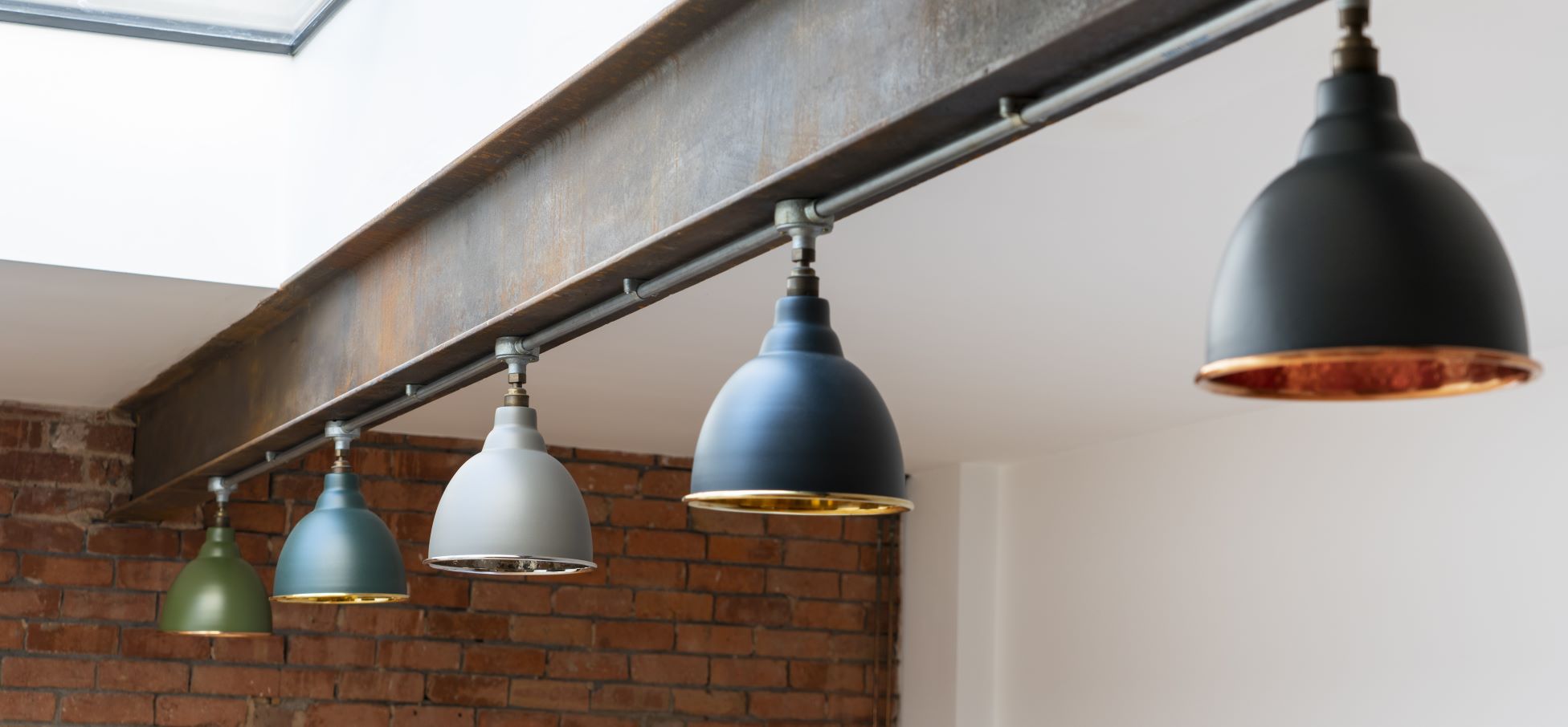 From The Anvil's Brindley ceiling pendant lights in multiple colours in an industrial room.