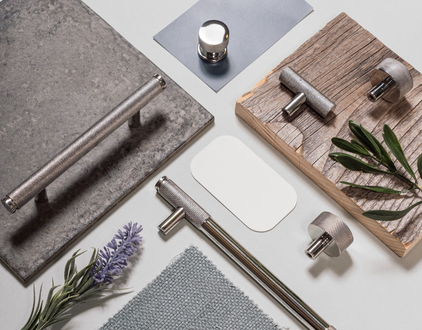 A mood board featuring From The Anvil's Polished Marine Stainless Steel cabinet hardware and an assortment of tiles, paint swatches, and fabric samples.