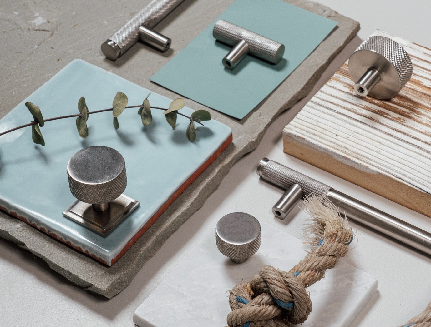 Mood board of From The Anvil's Satin Marine Stainless Steel hardware amongst an assortment of coloured tiles, paint swatches, and room decor.