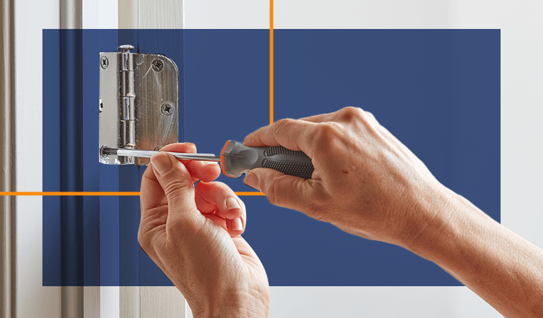 Person using a screwdriver to tighten a screw in a door hinge