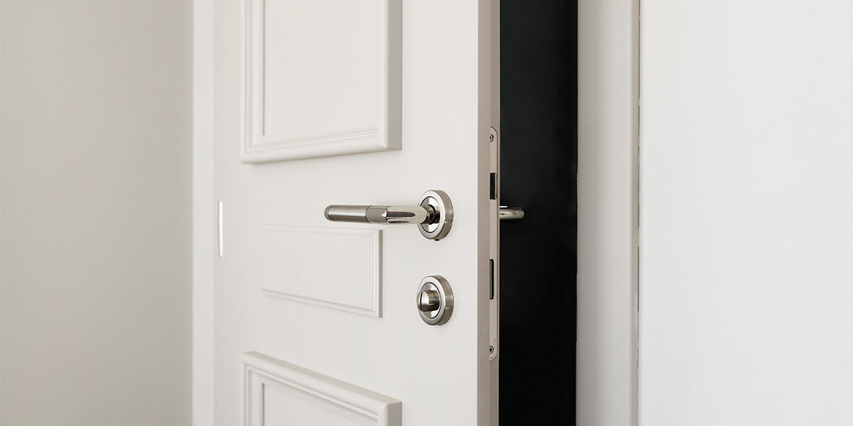 slightly opened white door with silver doorknob