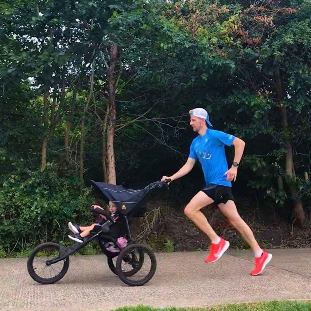 Man running with child in Nipper Sport running buggy