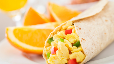 picture of an egg burrito with orange slices on the plate