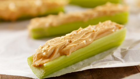 A close up of some stalks of celery with peanut butter