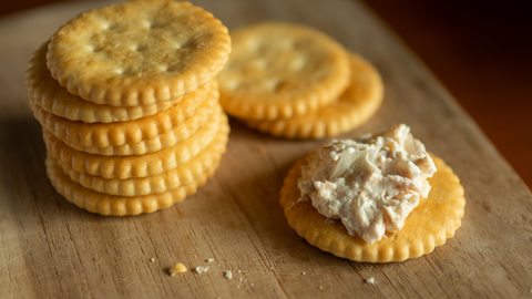 a picture of Ritz crackers with one having Tuna salad.