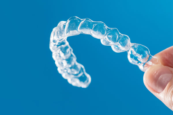 A hand holding Aligner32 Clear Aligner