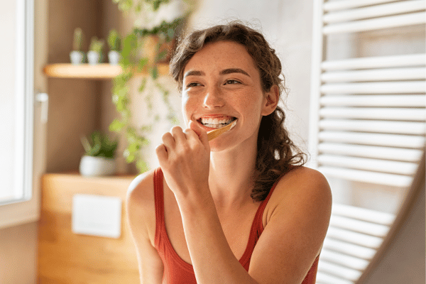  Woman Brushing Teeth at Mirror