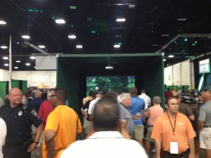 Attendees of the World Amateur Golf Championships walking around golf simulator