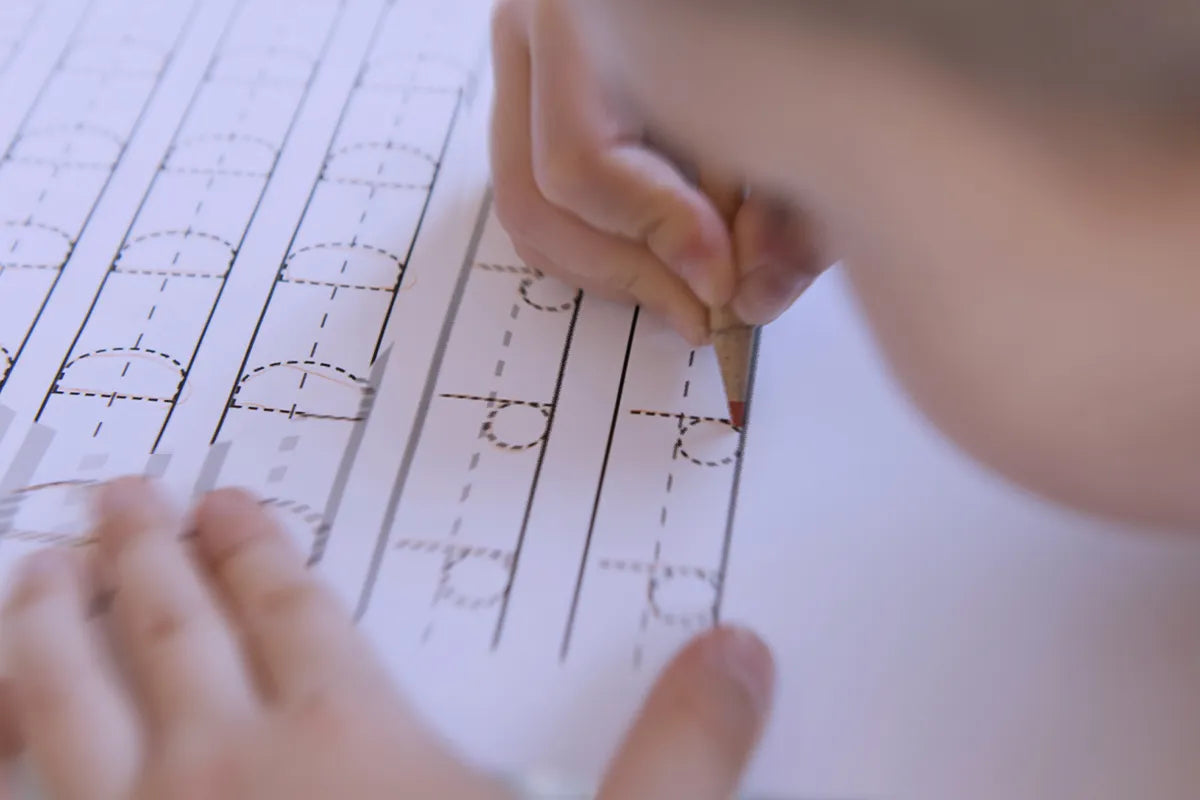 mano di un bambino che scrive la lettera d