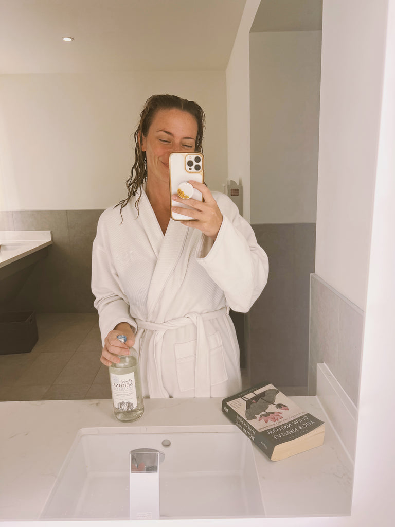 spa day ashley with book and water in robe