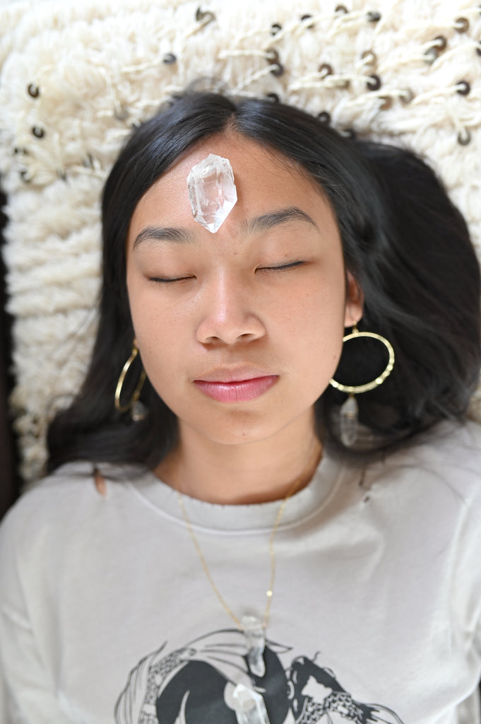 Woman With Quartz Resting on Forehead Meditating