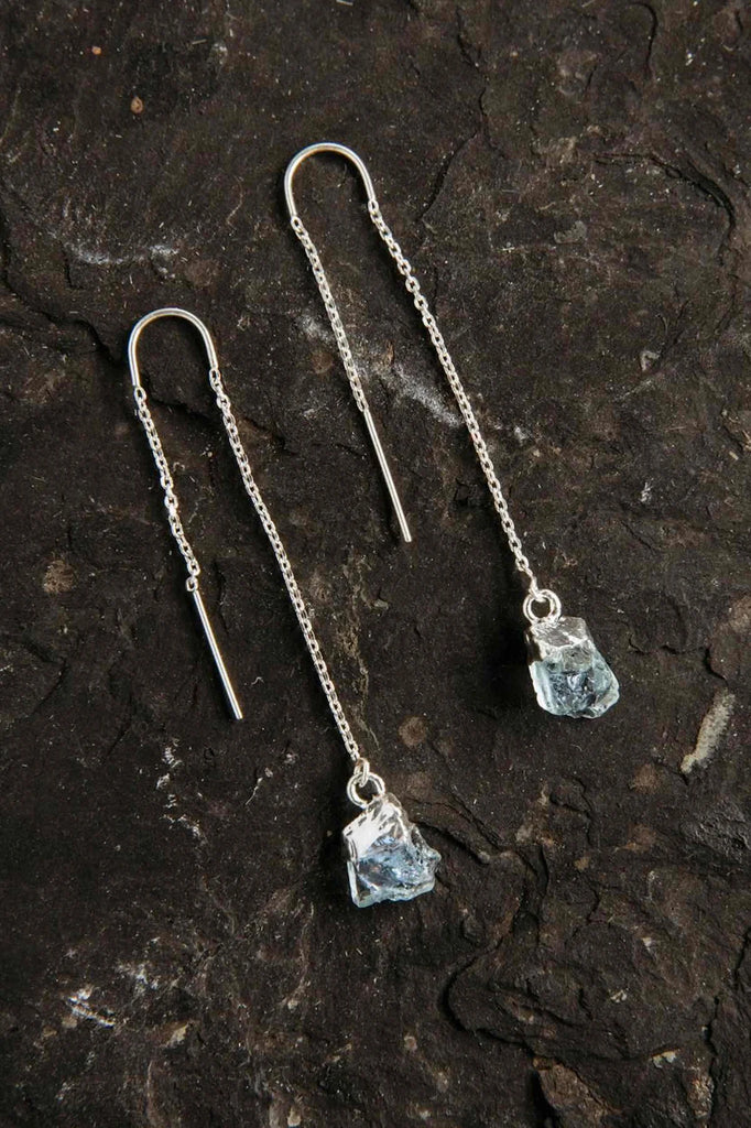 Two small aquamarine crystals on a silver threader-style earring