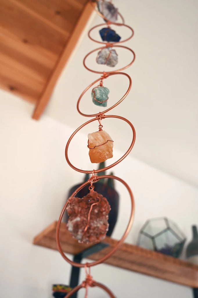 Raw crystals in a copper crystal hanger suspended from the ceiling