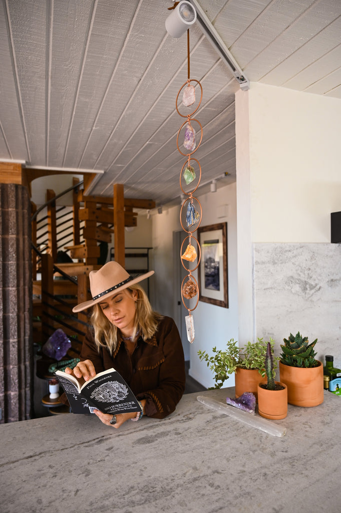 Woman sitting at counter reading a book to learn self-empowerment