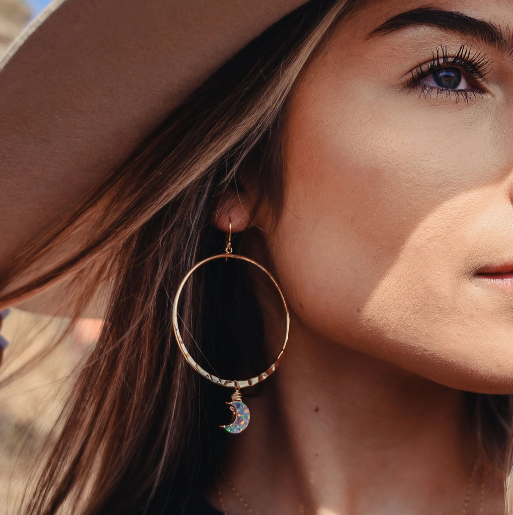 Woman wearing opal moon gold hoop earrings