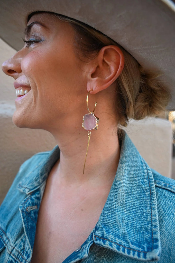 Woman smiling while wearing rose quartz crystal earrings for self-love