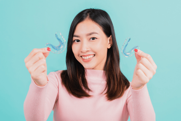 A girl holding orthodontic retainers