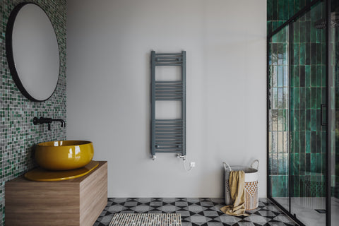 An image of a turquoise tiled bathroom with a grey radiator