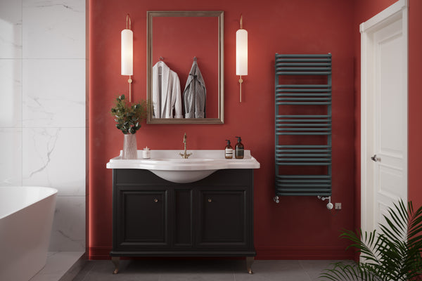 A bathroom in a rich red shade with integrated LED lighting coming from behind the bathtub nook, featuring an anthracite ladder towel rail.