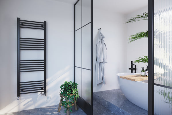 A modern bathroom with a bathtub platform and opaque room dividers separating the bathtub from the sink space and Zennor black towel rail.