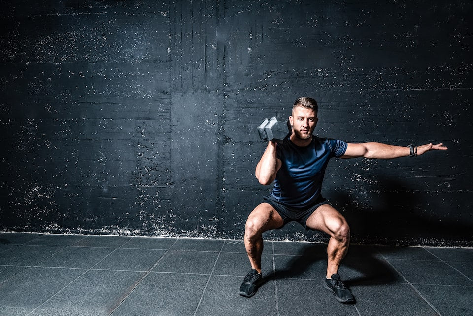 Athletic male performing full-body strength exercises. 