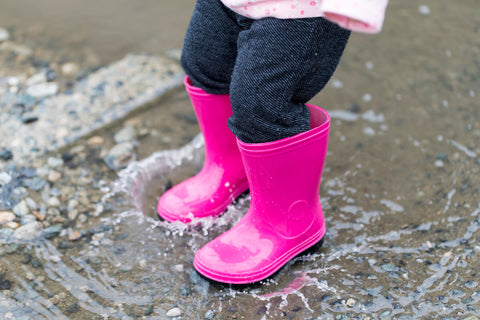 child jumping in puddle