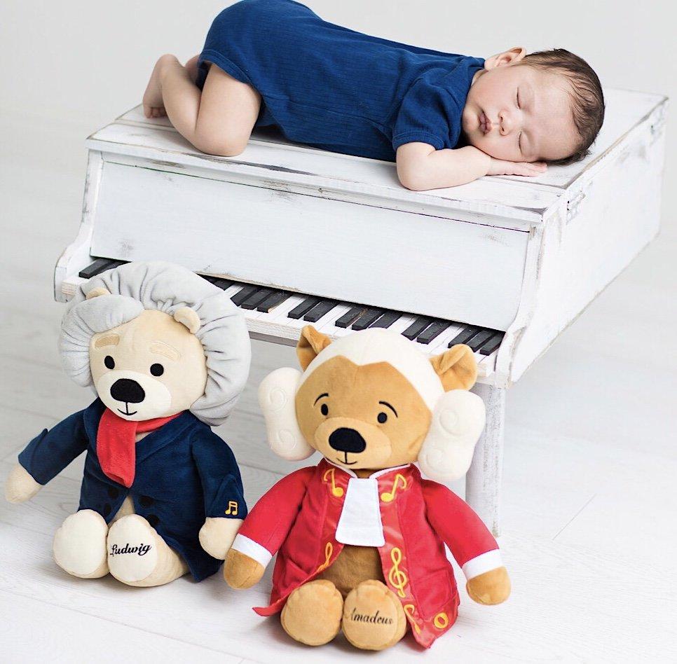 A baby peacefully sleeping next to three stuffed animals