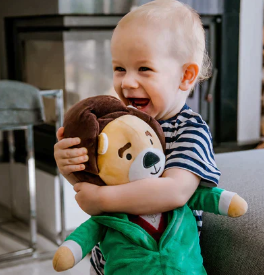 A toddler holding a stuffed animal, enhancing family bond through music playlist for stronger connections