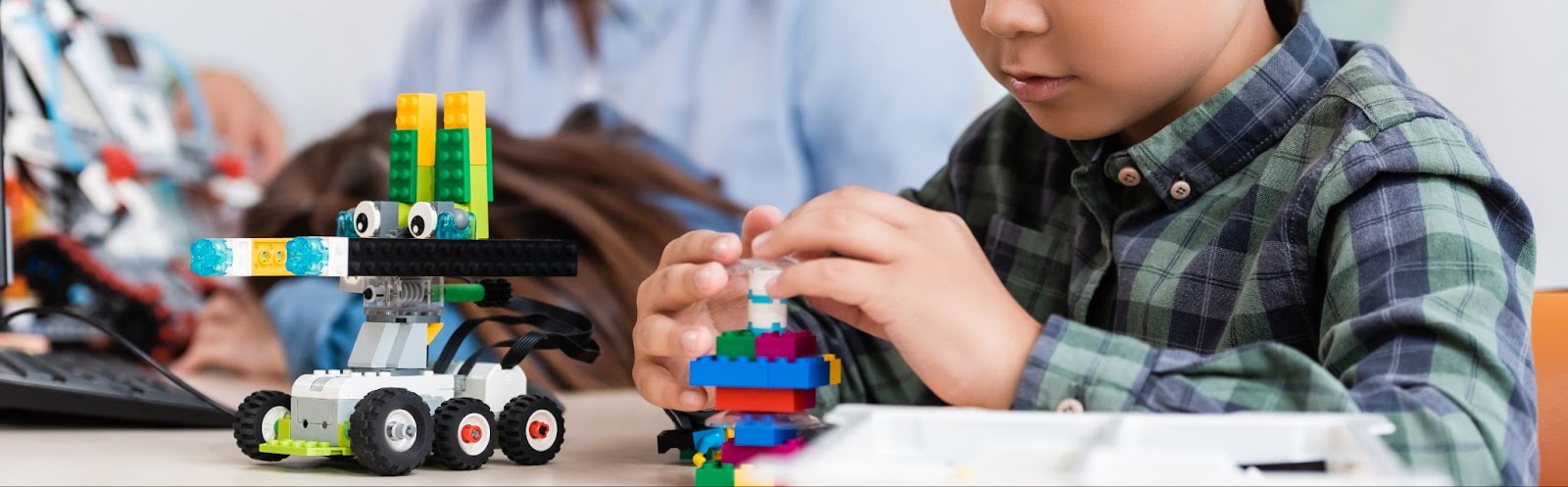 A young boy happily plays with Lego toys in a room filled with music-themed toys and gifts for babies