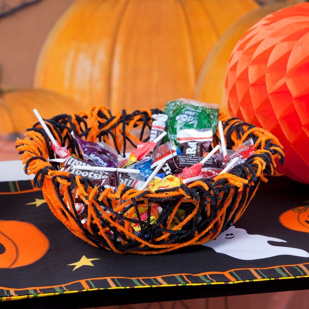 A basket of candy for the halloween treat is placed on the table