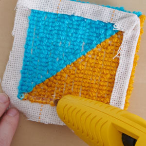 Step 5: Woman is holding a glue gun and putting glue on the edges