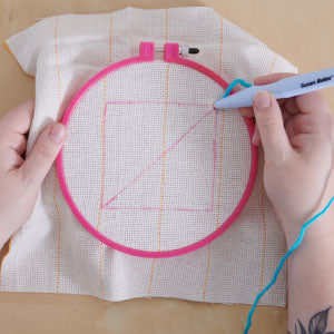 Step 4: Ring on cloth, woman's hand holding punch needle and making designs