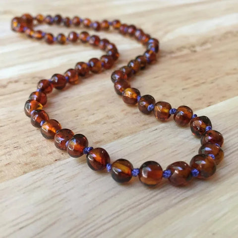 Polished cognac Baltic amber brown in color beads on purple jewelry thread knotted between beads necklace