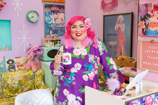 image of a pink haired woman behind a sales counter