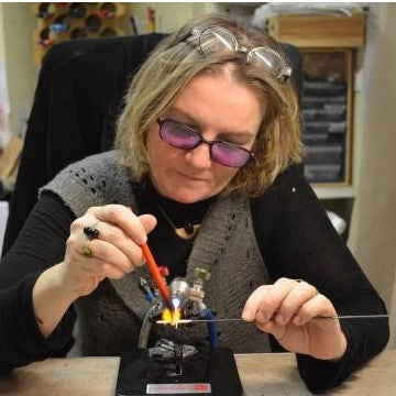 Nathalie en train de fabriquer une fleur en verre de Murano avec le feu d'un chalumeau