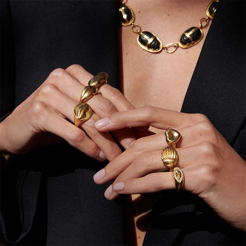 Close up of a woman with HEARTS, LIPS, SCARABS and PROTECTIVE EYES rings on both hands.