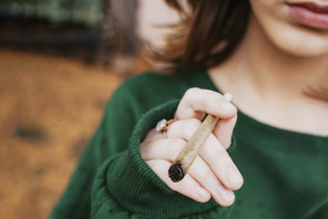 A woman holding a pre rolled cone joint