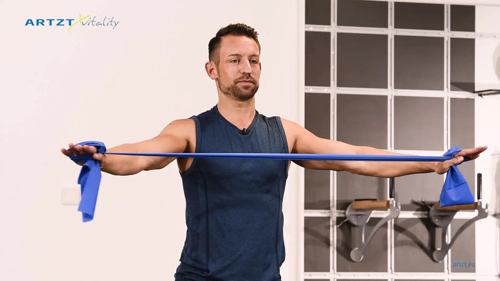 Man performs the arm extension exercise with a TheraBand.