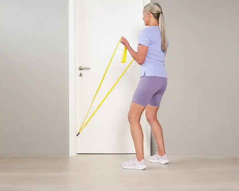 Woman doing TheraBand exercise for the biceps for more longevity - final position