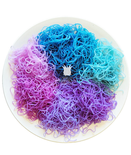 7 different colors of rice noodles colored with butterfly pea flowers and color change with citrus.