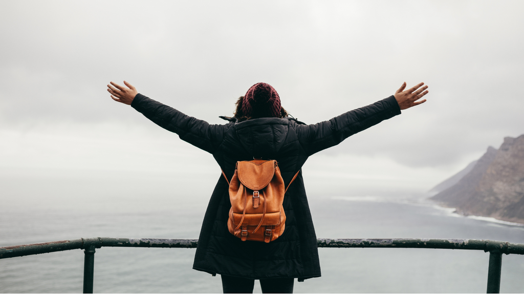 woman enjoying views of the ocean with hands in the air