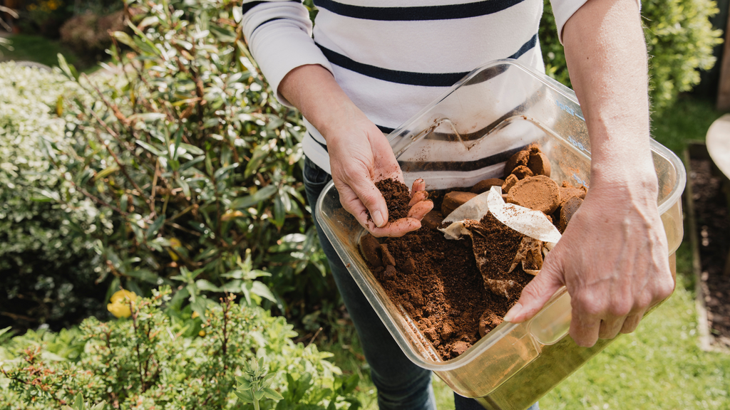 woman holding container of compost turned into fertilizer