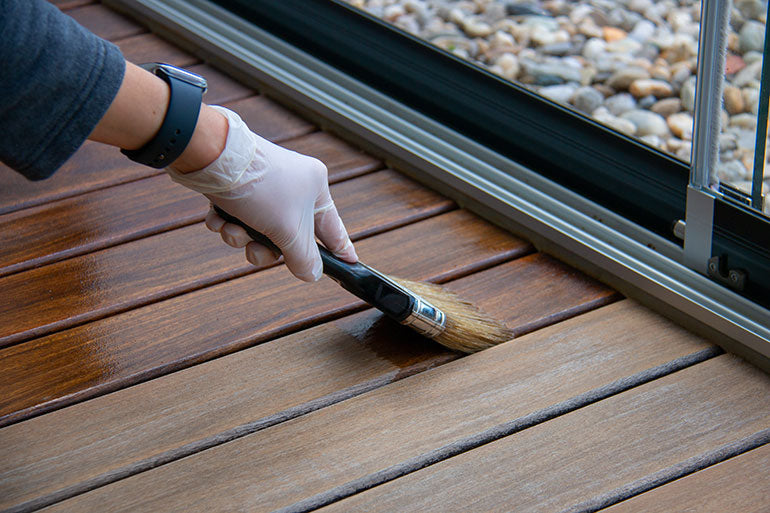 Applying dual-tone stain to outdoor deck.