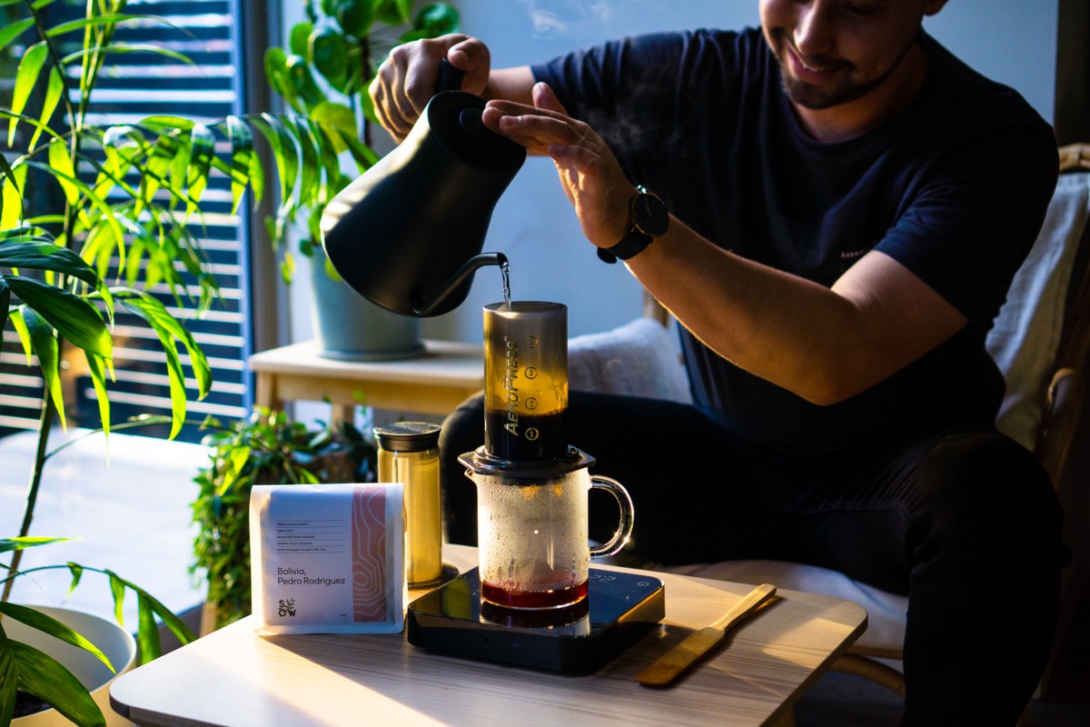 Charlie pours hot water into the Aeropress.