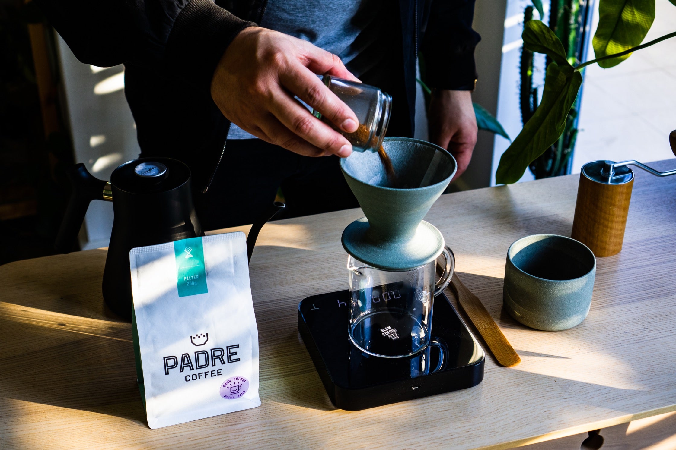 Charlie adds ground coffee to the pour-over.