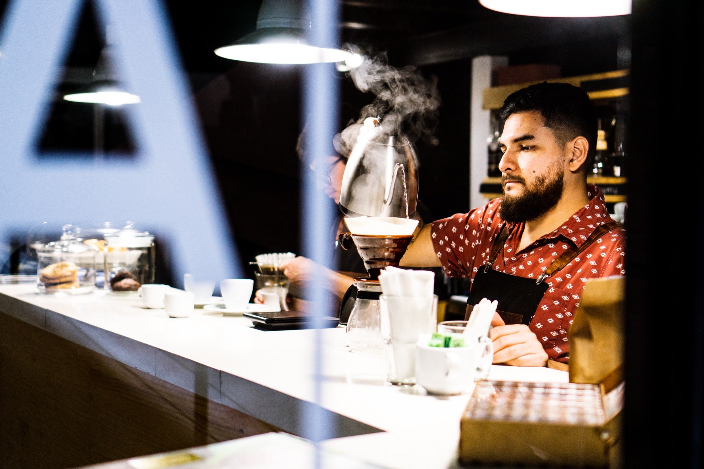 Oscar prepares coffee at La Mancha