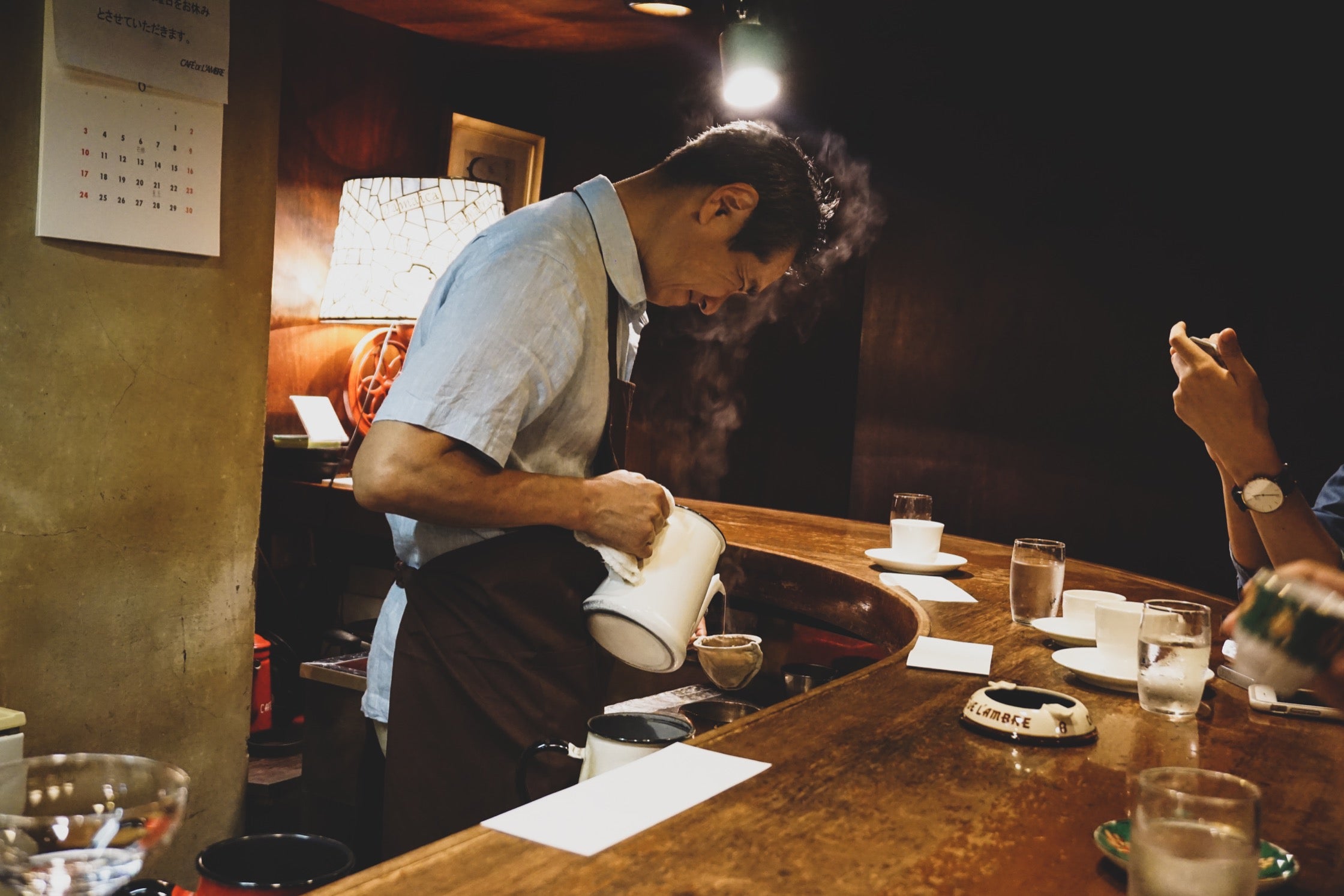 A bartender smiles while preparing coffee in a Toyko espresso bar