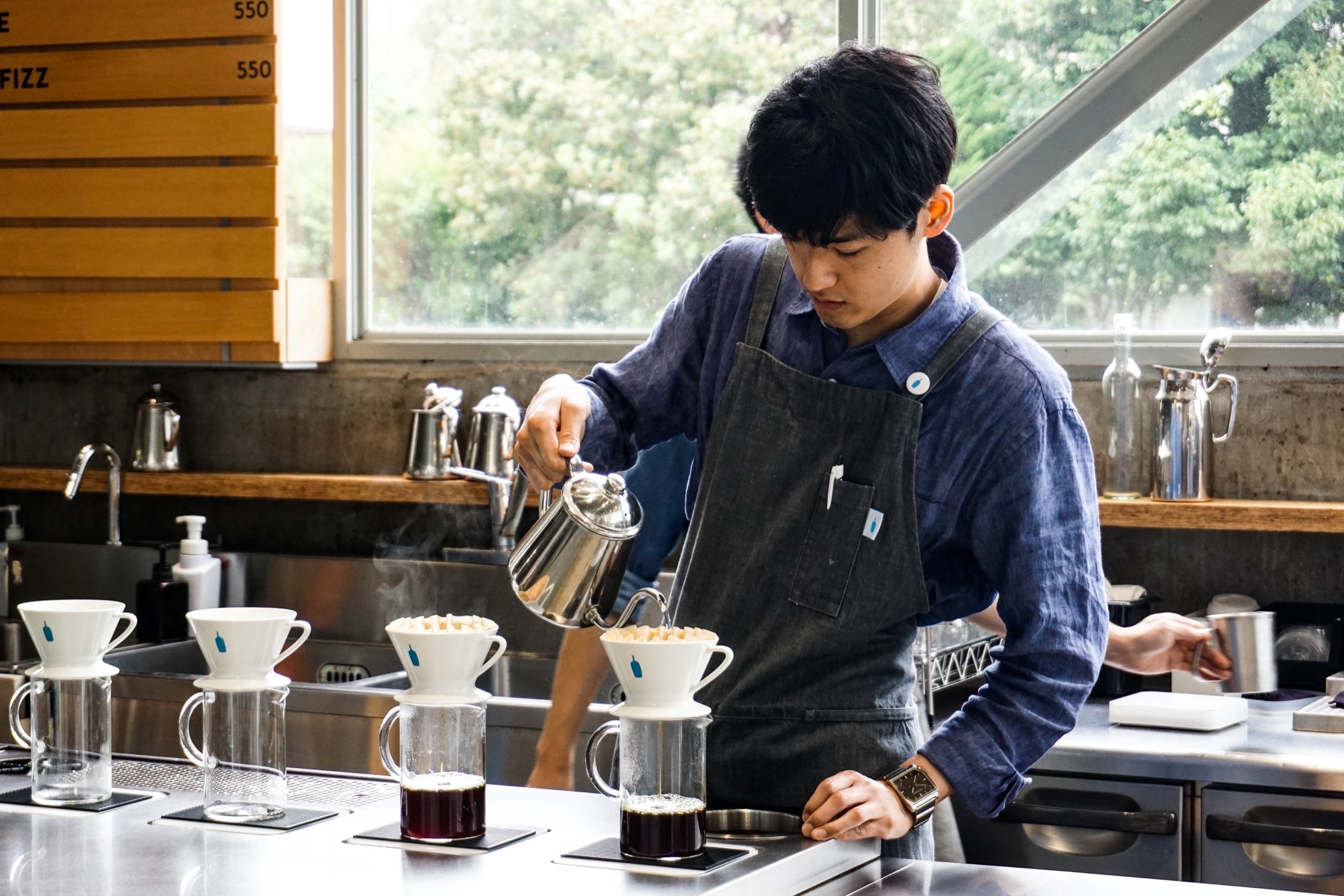 A barista adds hot water to a pour-over in a Toyko cafe